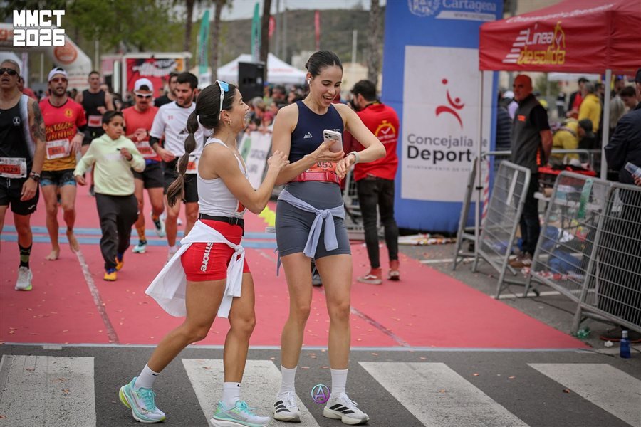 Corredoras comprobando su tiempo tras cruzar meta en la Media Maratón Ciudad de Cartagena 2026