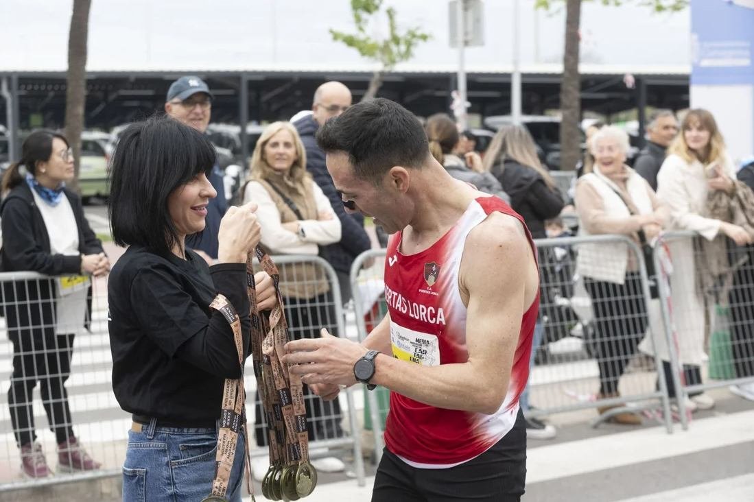 Entrega de medallas a un corredor tras cruzar la meta, edición anterior